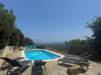 a swimming pool with lounge chairs and a swimming pool at Maison Authentique Corse Vue Mer Panoramique et Nature Sauvage in Zonza