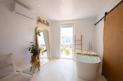 a large bath tub in a room with a window at Sublime, hyper-centre d'Ajaccio, avec Spa, Sauna, Vue mer & Plage à 3min in Ajaccio
