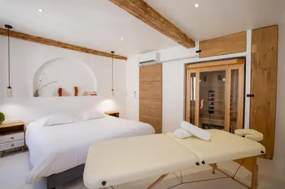 a bedroom with two beds and a table at Sublime, hyper-centre d'Ajaccio, avec Spa, Sauna, Vue mer & Plage à 3min in Ajaccio