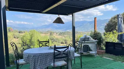 a table and chairs with a view of mountains at Le Gozzi in Afa