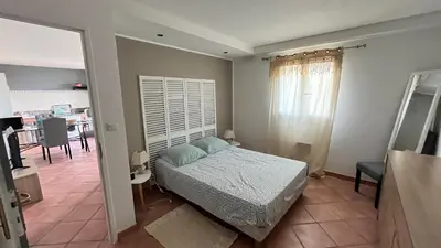 a bedroom with a bed and a dining room at Le Gozzi in Afa