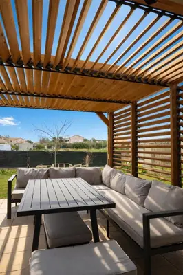a wooden table and chairs on a patio at Maison calme au bord de l'eau in Lucciana