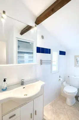 a white bathroom with a sink and a mirror at Maison calme au bord de l'eau in Lucciana