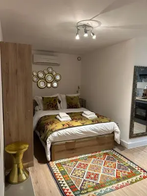 a bedroom with a bed and a mirror and a rug at Casa CARLU-MARIA IV in Corte
