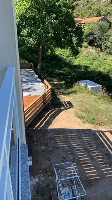 a porch of a house with a deck and a tree at U citraghju in Feliceto