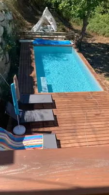 a swimming pool with a table and a chair at U citraghju in Feliceto