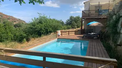 a swimming pool with a deck and a house at U citraghju in Feliceto