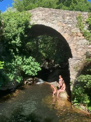 a group of people in the water under a bridge at U citraghju in Feliceto