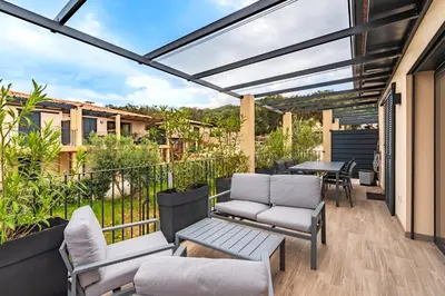 a patio with chairs and a table on a balcony at Padolo - 5min du Port de Bonifacio in Bonifacio