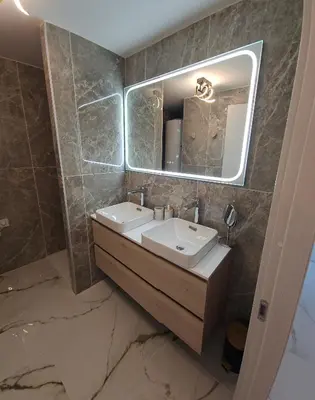 a bathroom with a sink and a mirror at Chez Vicky, superbe appartement avec parking privé piscine et vue exceptionnelle in Ajaccio