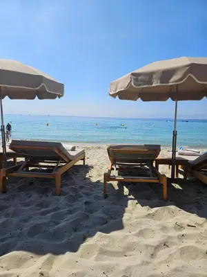 a group of chairs and umbrellas on a beach at Chez Vicky, superbe appartement avec parking privé piscine et vue exceptionnelle in Ajaccio