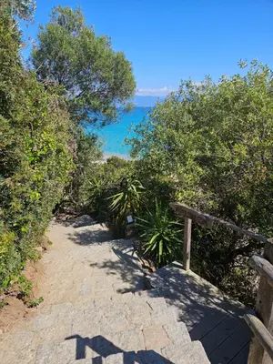 a path leading down to a beach with the ocean at Chez Vicky, superbe appartement avec parking privé piscine et vue exceptionnelle in Ajaccio
