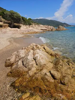 a beach with rocks and the water and the ocean at Chez Vicky, superbe appartement avec parking privé piscine et vue exceptionnelle in Ajaccio