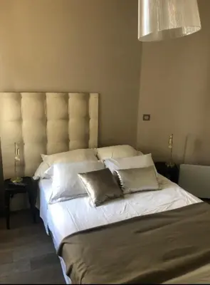 a bedroom with a large bed with white sheets and pillows at T2 pied dans l eau in Ajaccio