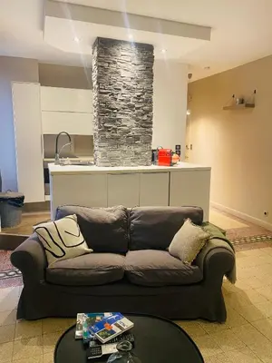 a living room with a couch and a stone fireplace at T2 pied dans l eau in Ajaccio