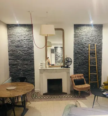 a living room with a fireplace and a mirror at T2 pied dans l eau in Ajaccio