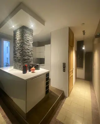a kitchen with a counter and a stone fireplace at T2 pied dans l eau in Ajaccio