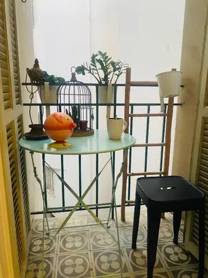 a table with a bird cage and plants on a balcony at T2 pied dans l eau in Ajaccio