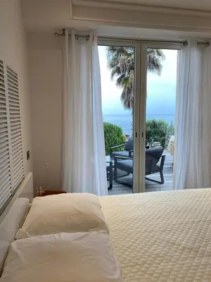 a bedroom with a bed and a view of the ocean at Vacances pieds dans l eau in Casaglione