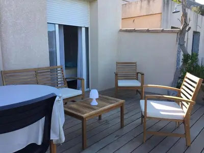 two chairs and a table on a deck at Vacances pieds dans l eau in Casaglione