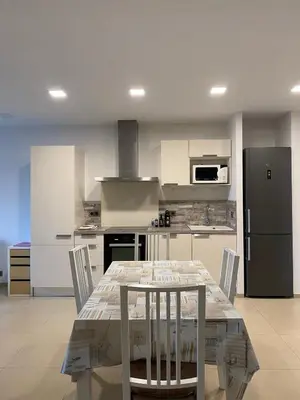 a kitchen with a table with chairs and a refrigerator at Vacances pieds dans l eau in Casaglione
