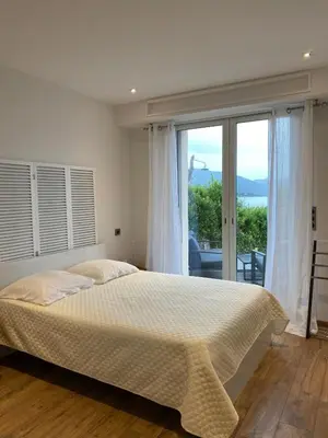 a bedroom with a bed and a large window at Vacances pieds dans l eau in Casaglione