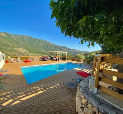 a swimming pool on a deck with a mountain in the background at Casa Maredda with private pool and large garden in Peri