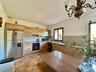 a kitchen with wooden cabinets and a stainless steel refrigerator at Casa Maredda with private pool and large garden in Peri