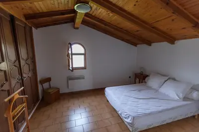 a bedroom with a bed and a wooden ceiling at Casa Maredda with private pool and large garden in Peri