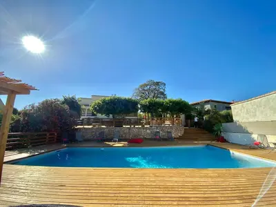 a swimming pool in a yard with a wooden deck at Casa Maredda with private pool and large garden in Peri