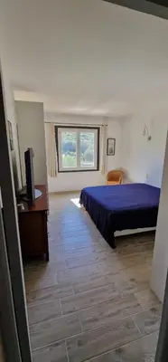 a bedroom with a bed and a desk and a window at villa terra et mare in Oletta