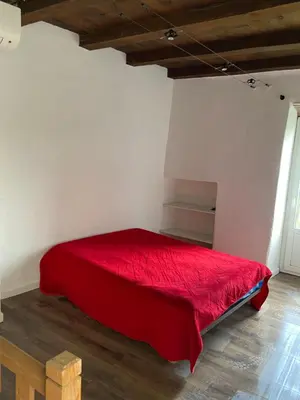 a bedroom with a red bed in a room at Sottu à a Citadella in Corte