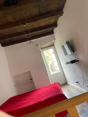 a bedroom with a red bed and a window at Sottu à a Citadella in Corte