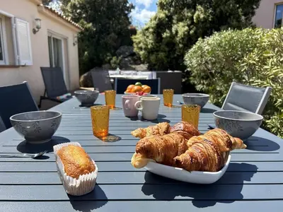 a table with croissants and other pastries on it at Villa 3 chambres dans résidence avec piscine in Porto-Vecchio