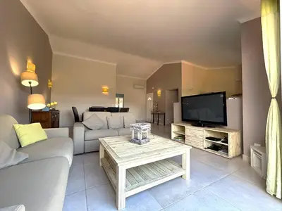 a living room with a couch and a tv at Villa 3 chambres dans résidence avec piscine in Porto-Vecchio