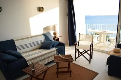 a living room with a blue couch and a table at Merveilleux, sur la plage et accès direct à la mer in Olmeto