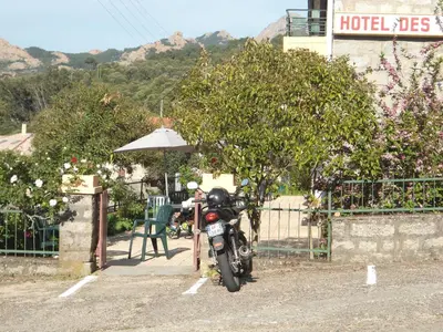 a motorcycle parked in a parking lot next to a building at Hotel Les Calanques in Piana