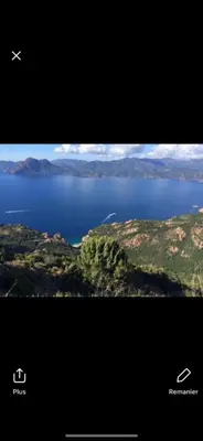 a view of a lake with an airplane flying over it at Hotel Les Calanques in Piana