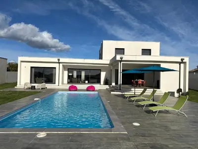 a house with a swimming pool and some chairs at Spacieuse villa standing de 220m2 in Aléria