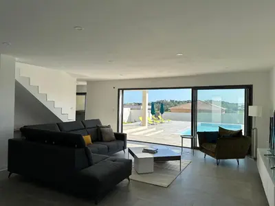a living room with a couch and chairs and a pool at Spacieuse villa standing de 220m2 in Aléria
