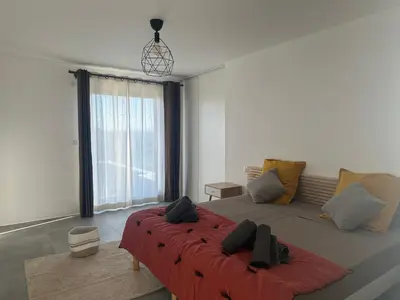 a bedroom with a large bed and a large window at Spacieuse villa standing de 220m2 in Aléria