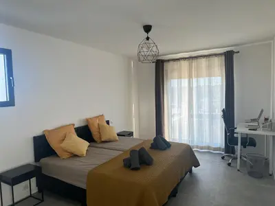 a bedroom with two beds and a desk and a window at Spacieuse villa standing de 220m2 in Aléria