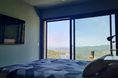 a bedroom with a bed and a large glass window at New quiet upscale air-conditioned villa T2 with heated pool & sea view in Sollacaro