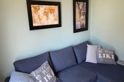 a blue couch in a living room with two pillows at New quiet upscale air-conditioned villa T2 with heated pool & sea view in Sollacaro