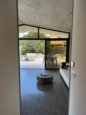 a door to a living room with a couch and a table at La petite maison Corse in Porto-Vecchio