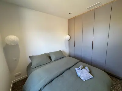 a small bedroom with a bed and a cabinet at La petite maison Corse in Porto-Vecchio