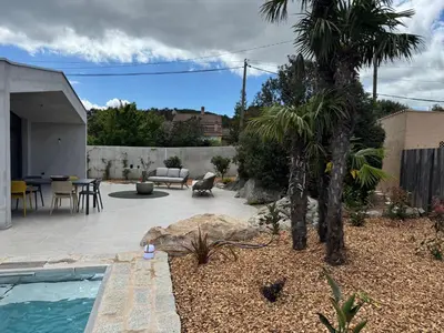 a backyard with a swimming pool and a palm tree at La petite maison Corse in Porto-Vecchio
