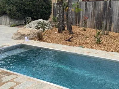a swimming pool in a yard with a fence at La petite maison Corse in Porto-Vecchio