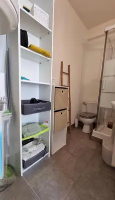 a bathroom with a white shelving unit with a toilet at Charmant Type 2 hyper centre in Corte