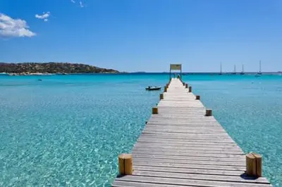 a wooden pier in the middle of the water at Mini Villa Santa Giulia double vue mer à 5 min de la plage à pied in Porto-Vecchio